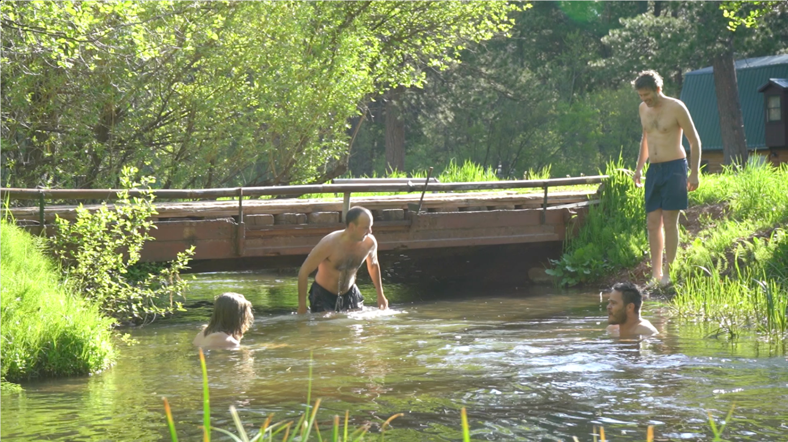 Guests in the creek below the footbridge at The Wagon Box
